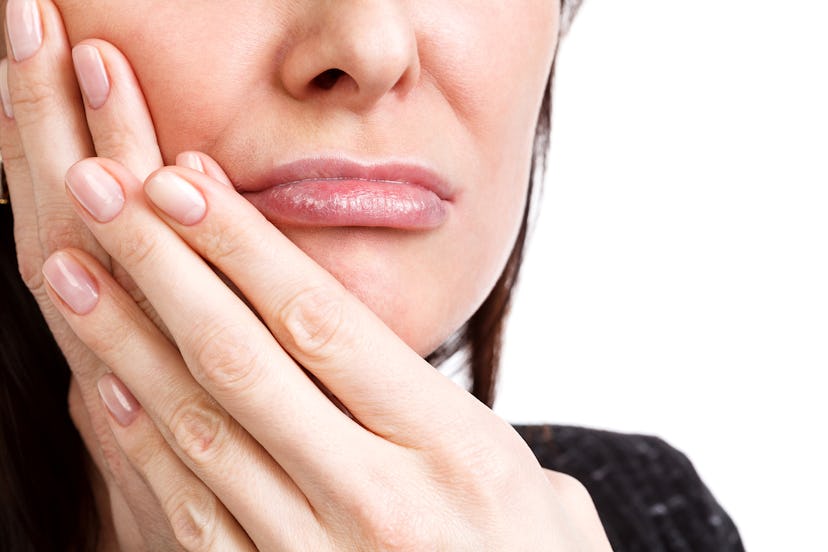 Woman with a toothpain, isolated on white background