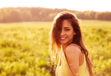 Beautiful toothy natural smiling relaxing woman looking happy with long amazing hair on nature brigh...