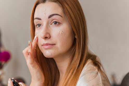 Woman applying foundation and concealer makeup. Do it yourself makeup for problem skin