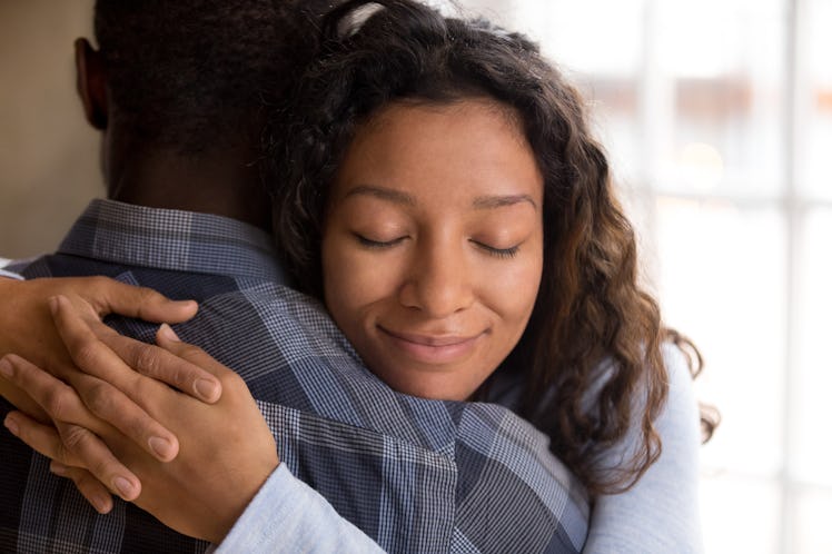 Happy african american wife hugging husband holding tight feeling grateful, smiling woman in love em...