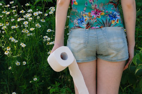Woman take toilet paper. Back view. Concept of diarrhea. Natural toilet paper