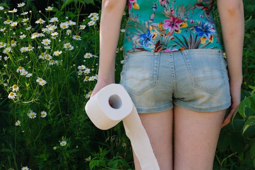Woman take toilet paper. Back view. Concept of diarrhea. Natural toilet paper