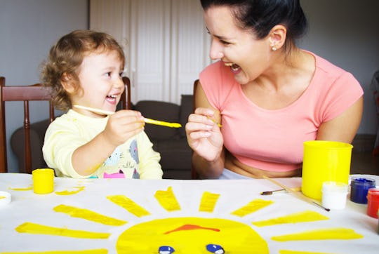 The babysitter is drawing with the baby