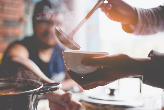 Woman holding ladle in the hand for preparing dinner.