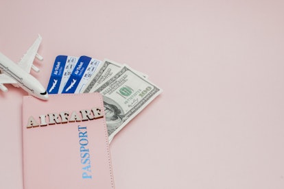 Inscription "airfare", Airplane, air ticket and money on a pink background. Travel concept, copy spa...