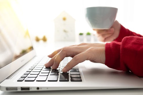 Businesswoman using smartphone and laptop writing on tablet on white table in coffee shop with a cup...