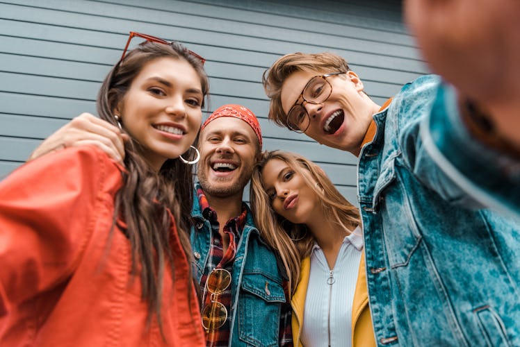 cheerful stylish friends taking selfie together