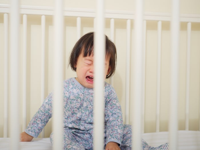Crying Baby girl in cot bed
