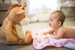 newborn baby doing tummy time in an article about when can babies hold their head up?
