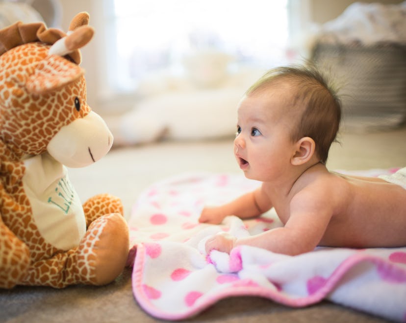 newborn baby doing tummy time in an article about when can babies hold their head up?