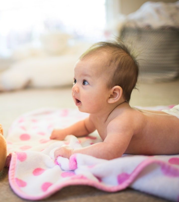 newborn baby doing tummy time in an article about when can babies hold their head up?