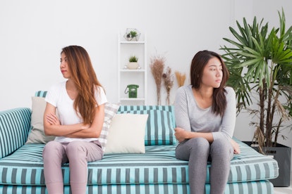 Asia lesbian lgbt couple quarrel sitting each side of sofa with moody emotion in living room 