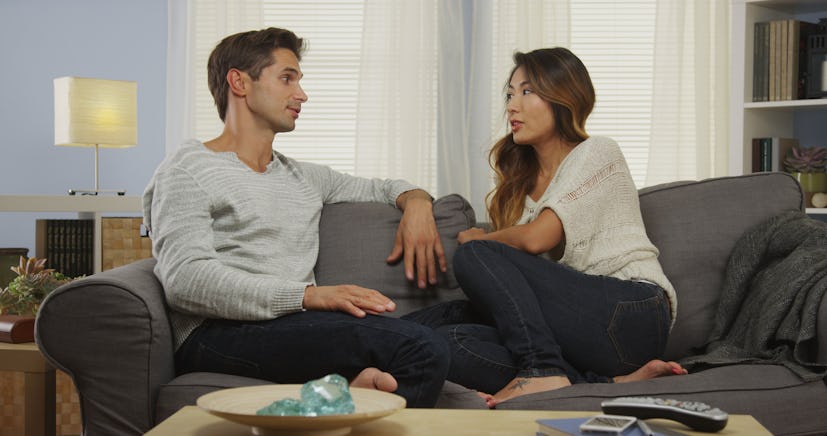 Mixed race couple talking on couch