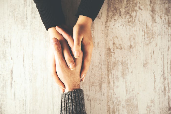 woman and man hand on wooden table