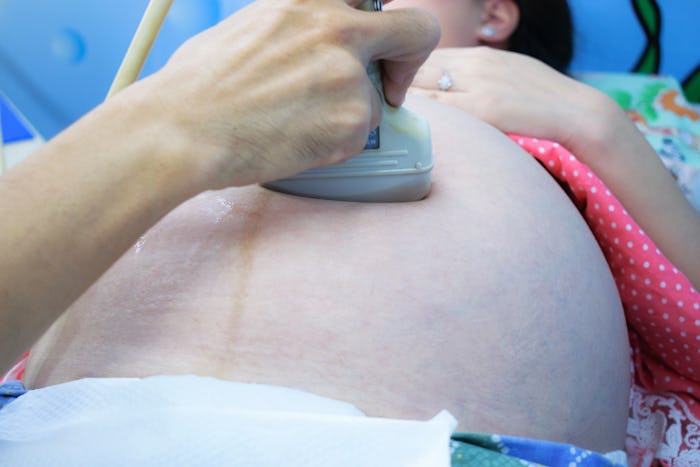 Pregnant woman getting ultrasound from doctor. Ultrasound examination of the pregnant woman.