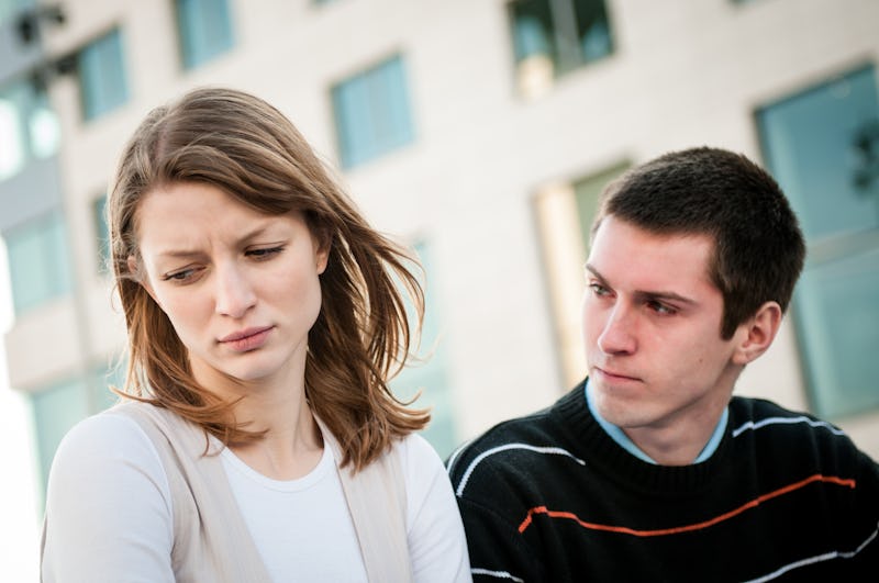 Lifestyle image of young woman and man outside on street having relationship problems