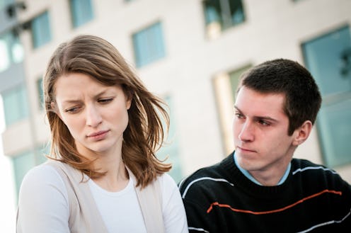 Lifestyle image of young woman and man outside on street having relationship problems