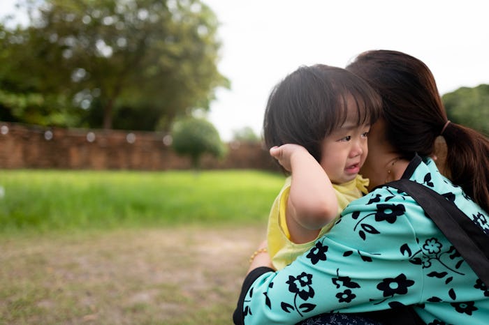 Asian children feel sad to hug mother in the garden.