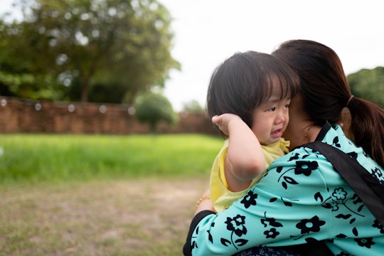 Asian children feel sad to hug mother in the garden.