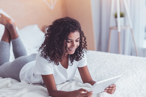 Smiling girl. Smiling girl wearing white T-shirt feeling very relaxed while watching funny comedy on...