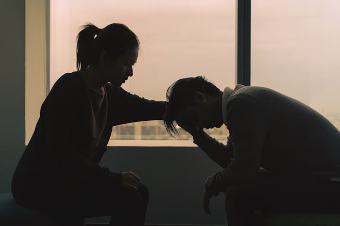 couple sitting near window in dark room at evening time with low light environment