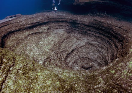 Diver floating on underwater volcano crater