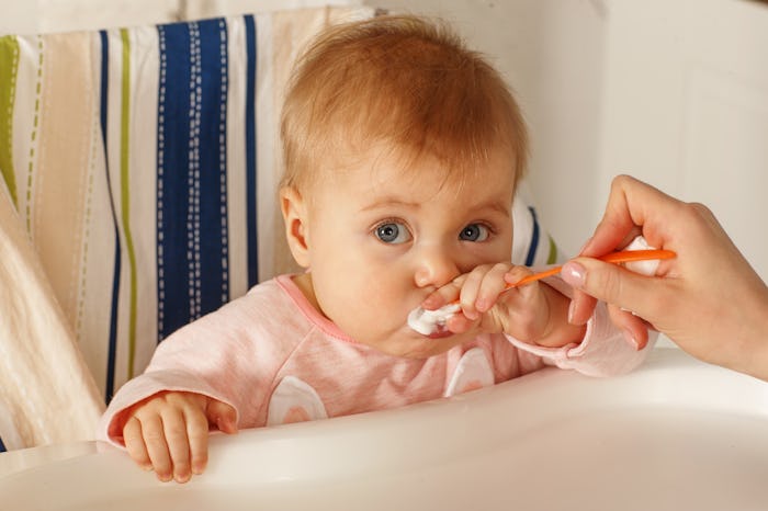 baby girl learning to use a spoon
