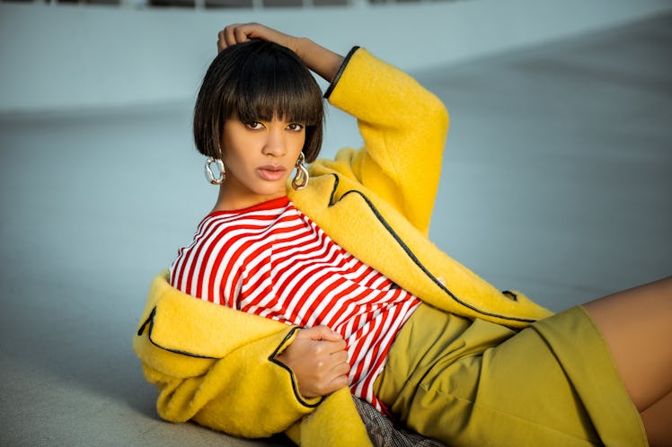 Yellow themed lady. Appealing sexy woman elegantly lying on the ground decorated with silver jewelry