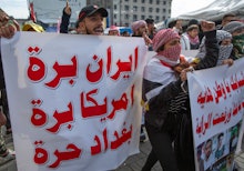 Anti government Iraqi protesters chant anti Iran and anti U.S. slogans and carry a poster that reads...