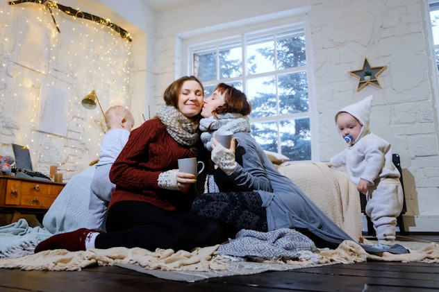 Unconventional family. Happy mom lesbians play in the morning with their sons. Christmas morning. Ch...