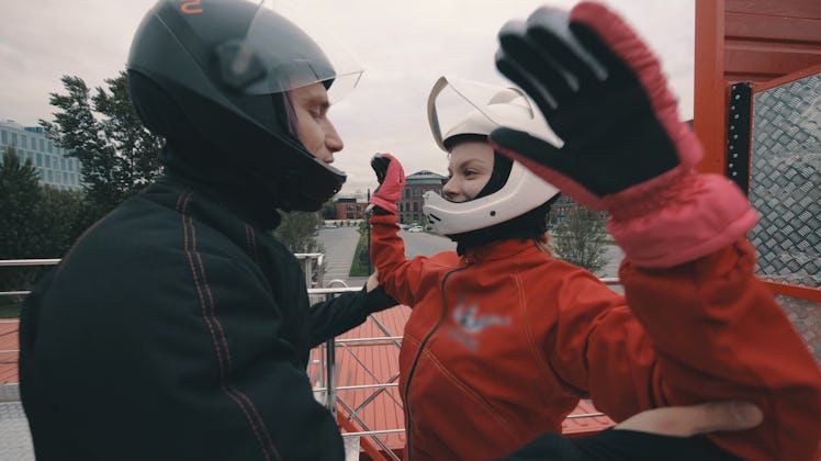 Male coach instructs a skydiver girl before flying into wind tunnel