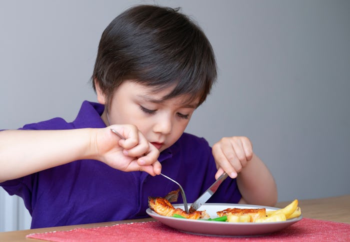little boy eating salmon