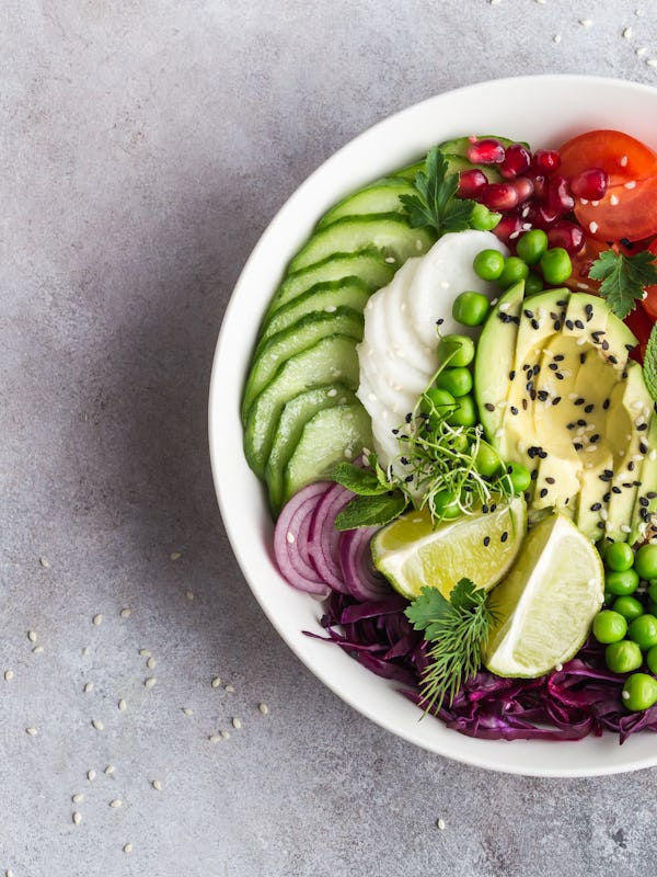 healthy vegan lunch bowl. Avocado, quinoa, tomato, cucumber, red cabbage, green peas and radish  veg...