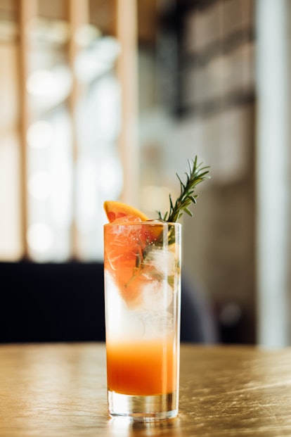 Paloma cocktail with fresh grapefruit on the wooden table, vertical composition