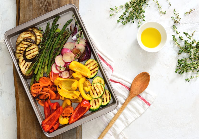 Simple vegetarian meal, roasted vegetables on a sheet with olive oil and thyme, overhead view