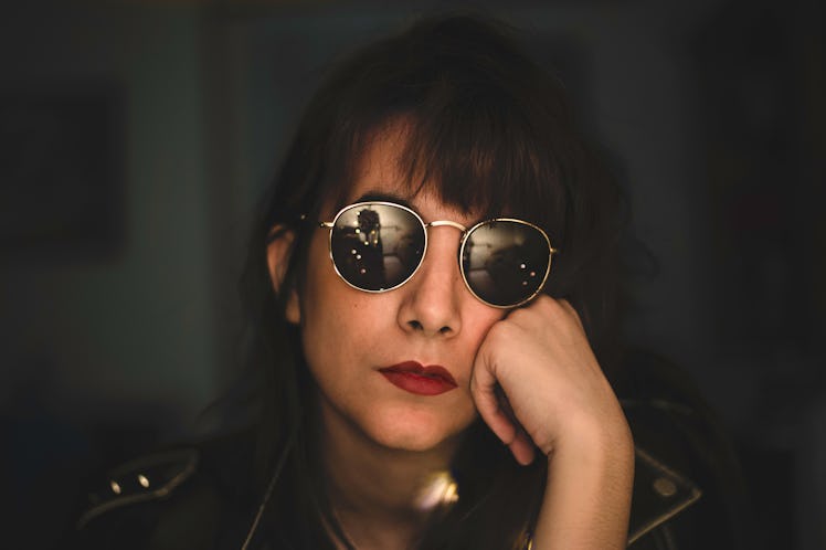 Rock woman resting on her hand with sunglasses and red lips