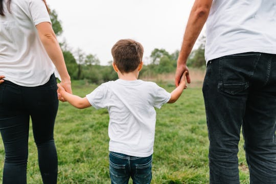 mom, dad, and little boy walking and holding hands outside