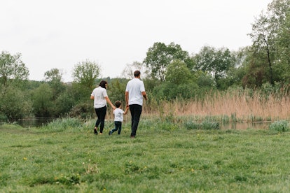 Happy family: mother father and child son on nature on sunset. Mom, Dad and kid laughing and hugging...