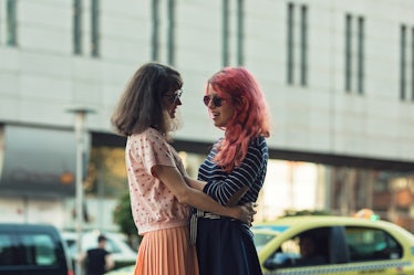 two lesbian girls, couple kiss romantically on the street in the city show love to each other gay pr...
