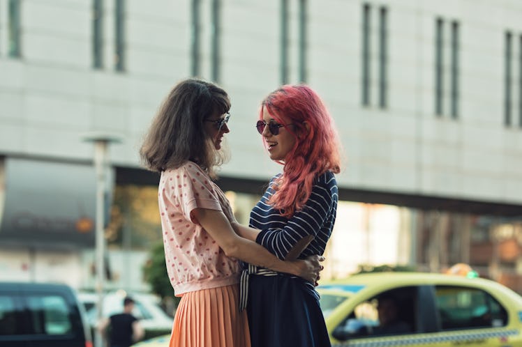 two lesbian girls, couple kiss romantically on the street in the city show love to each other gay pr...