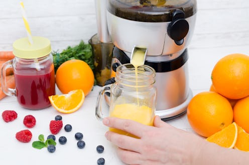 Preparing juice from fresh fruits and vegetables. Electric juicer, healthy lifestyle concept