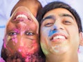 Close-up the young happy couple lying face to face with paints on their faces and smiling