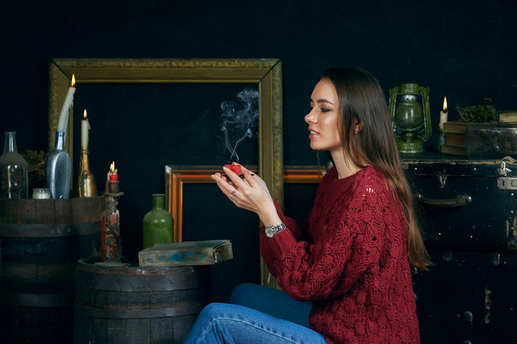young woman with candles on dark background, divination and spiritualism