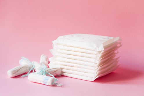 women intimate hygiene products - sanitary pads and tampons on pink background