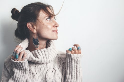Boho jewelry on model: ethnic stone rings and earrings. Beautiful woman wearing warm woolen sweater ...