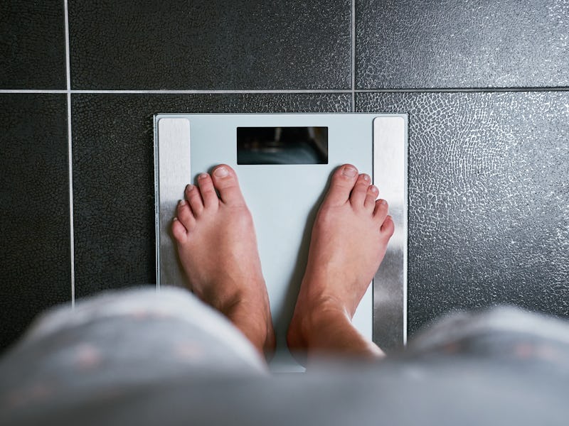 Female bare feet with weight scale, top view