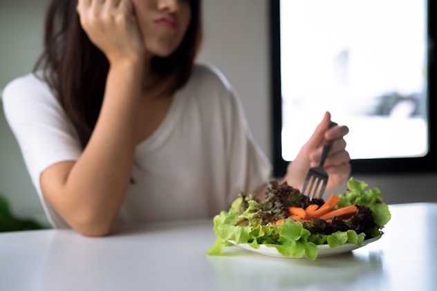 Unhappy women is on dieting time, girl do not want to eat vegetables.