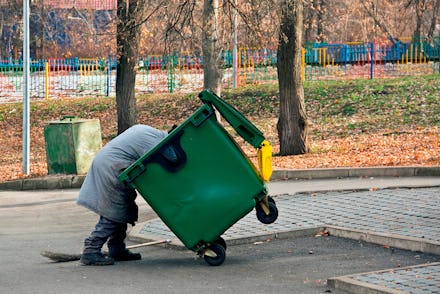 Man digs in the trash. Homeless and jobless person