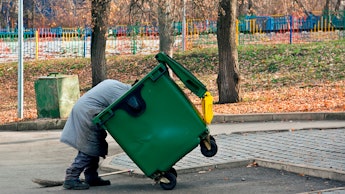 Man digs in the trash. Homeless and jobless person