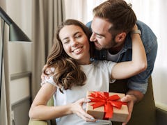 A happy couple exchanges a present at home.